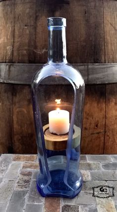 a candle is lit in a glass bottle