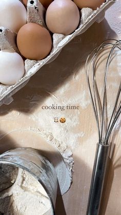 eggs and flour in cartons sitting on a table next to a whisk