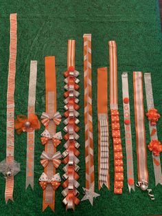 an assortment of orange and silver ribbons laid out on green carpeted area next to each other