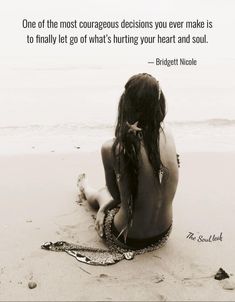 a woman sitting on top of a sandy beach next to the ocean with a quote above her