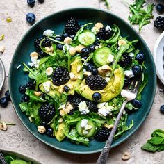 a green salad with blackberries and avocado