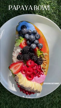 a white plate topped with a slice of cake covered in berries and kiwis