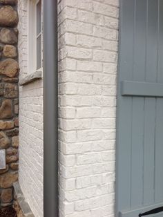 two doors are open in front of a brick building with stone pillars on either side