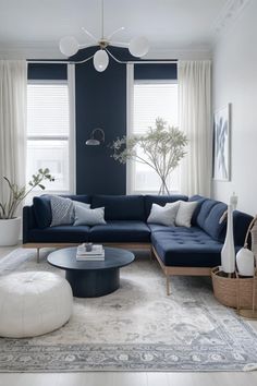 a living room with blue couches and rugs in front of two large windows