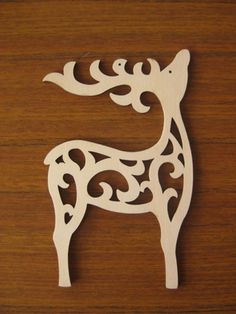 a wooden cutout of a giraffe on top of a wood surface with an intricate design