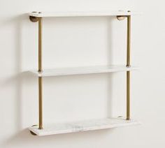 two white shelves with gold handles against a wall