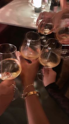 several people are holding wine glasses in their hands and toasting them with each other