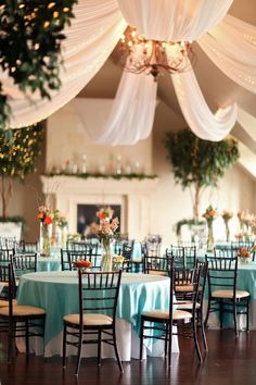 the tables are set with blue linens and white draping for an elegant wedding reception