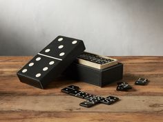 two dominos in a box on a wooden table next to other domino pieces and dices