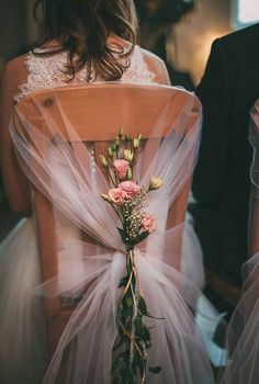 the back of a bride's chair with flowers on it