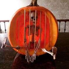 a skeleton in a pumpkin cage sitting on top of a table