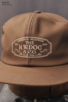 Made in 100% cotton. One size. Brand: HW Dog & Co. Made in Japan Pre-washed Snapback Hat, One Size Fits Most, Pre-washed Cotton 5-panel Hat, Classic Cotton Fitted Hat With Embroidered Logo, Classic Cotton Trucker Hat With Embroidered Logo, Pre-washed Snapback Hat, Classic Cotton Cap, Classic Cotton Hat, Vintage Brown Hat For Everyday, Everyday Vintage Brown Hat