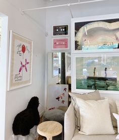 a living room filled with furniture and pictures on the wall