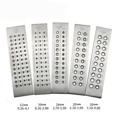 four metal grates with holes and numbers on them