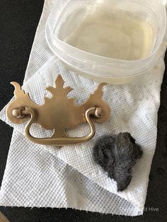 a piece of metal sitting on top of a white towel next to a plastic container