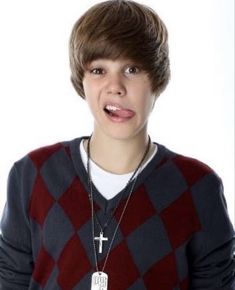 a young man with a cross on his chest wearing a red and grey sweater, necklaces and a white t - shirt