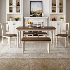 a dining room table with two chairs and a bench in front of the fireplace area