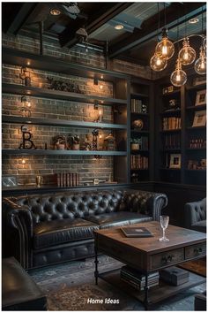 a living room filled with black furniture and lots of bookshelves on the wall