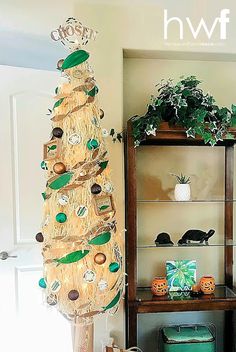 a decorated christmas tree in the corner of a living room next to a book shelf