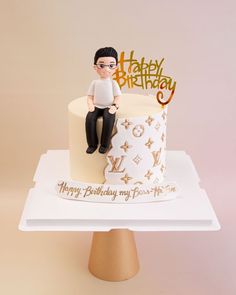 a birthday cake with a man sitting on top of it