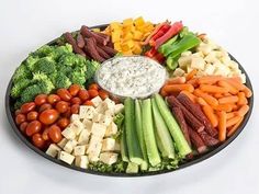 a platter filled with vegetables and dip