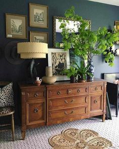 a living room filled with lots of furniture and pictures on the wall next to a dresser