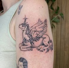 a woman with a tattoo on her arm has an image of a unicorn and a man's face