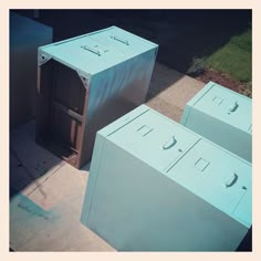 three metal boxes sitting on the sidewalk next to each other