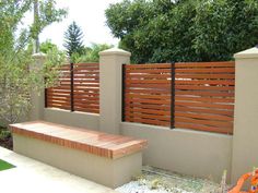 a wooden fence next to a brick bench