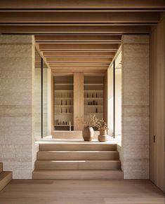 an empty room with some stairs leading up to the second floor and a planter on the far wall