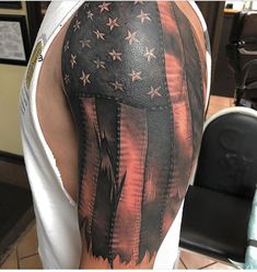 an american flag tattoo on the back of a man's left arm and shoulder