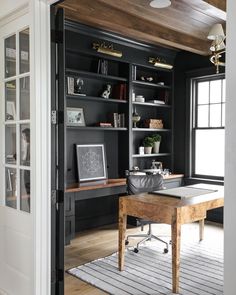 a home office with built in bookshelves and desk