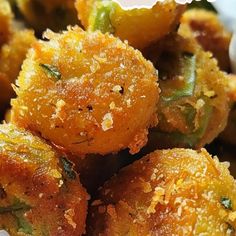 some fried food on a white plate with seasoning sprinkles and green peppers