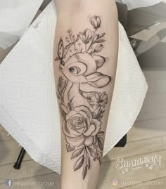 a black and white photo of a woman's leg with flowers on the side