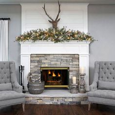 the living room is decorated for christmas with deer head on the wall above the fireplace