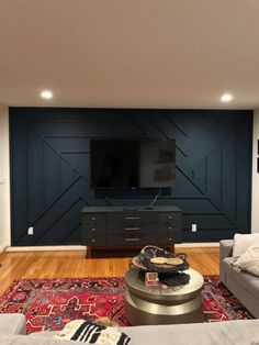 a living room filled with furniture and a flat screen tv mounted on a wall above a fireplace