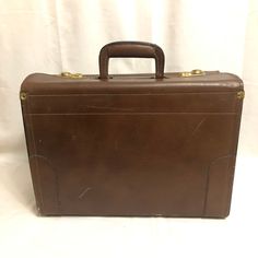 This is a super cool vintage brown leather suitcase. Even if you have no intention on using this as a bag, this would still be an amazing decorative piece to have in the home! There's noticeable wear on all throughout this piece. It's scuffs and scratches are part of its history - imagine all of the places this trunk has traveled to. Approximate Measurements: Height: 12 inches Length: 16 inches Depth: 7 inches Handle drop: 2.25 inches Buy with confidence! All of our packages are insured, so you Brown Rectangular Travel Case, Rectangular Travel Bag With Leather Lining, Classic Brown Travel Cases, Brown Rectangular Satchel For Travel, Brown Rectangular Travel Satchel, Brown Cases With Luggage Sleeve For Trip, Brown Briefcase With Luggage Sleeve For Trips, Brown Rectangular Travel Briefcase, Formal Brown Travel Bag With Luggage Sleeve