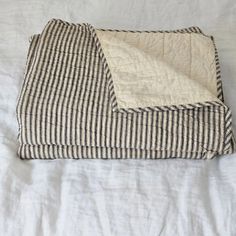 a black and white blanket laying on top of a bed