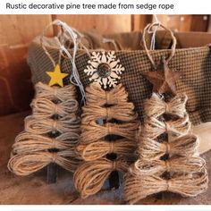 three christmas trees made from rope on top of a wooden table next to a bag