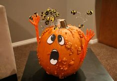 a decorated pumpkin with bees on it's head and hands in the shape of a face