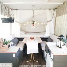 the inside of a camper with a bed and kitchenette in it's center