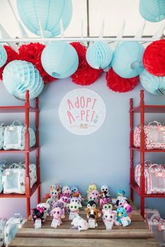 there is a table with many items on it and paper lanterns hanging from the ceiling