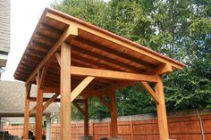 an outdoor covered patio with wooden posts and roof