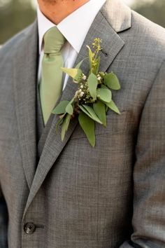 a man wearing a gray suit and green tie