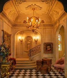 the interior of an ornately decorated house with chandelier and staircase leading up to it