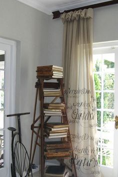 a room with a ladder and books on the floor