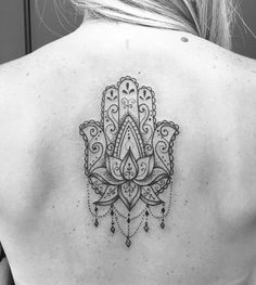 a woman's back with a tattoo design on it