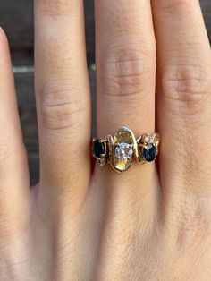 a woman's hand with a ring on it and three stones in the middle