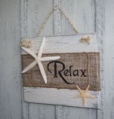 a sign that says relax with starfish on the front and side of it hanging from a rope