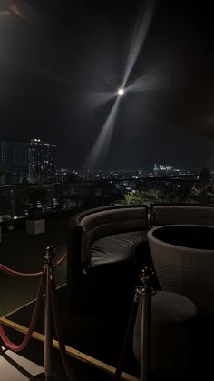 an outdoor seating area at night overlooking the city lights